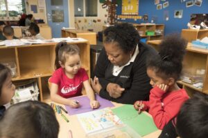 young-girl-coloring-picture-with-teacher